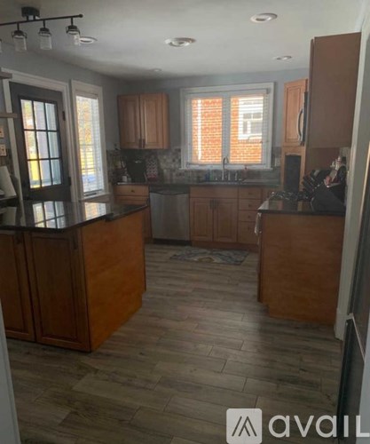 A kitchen with wooden cabinets and a tiled floor.