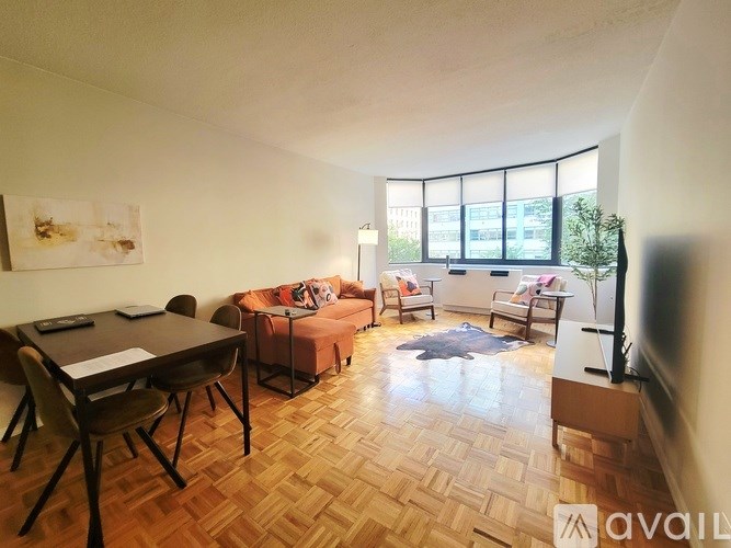 A living room with a wooden floor and a large window.