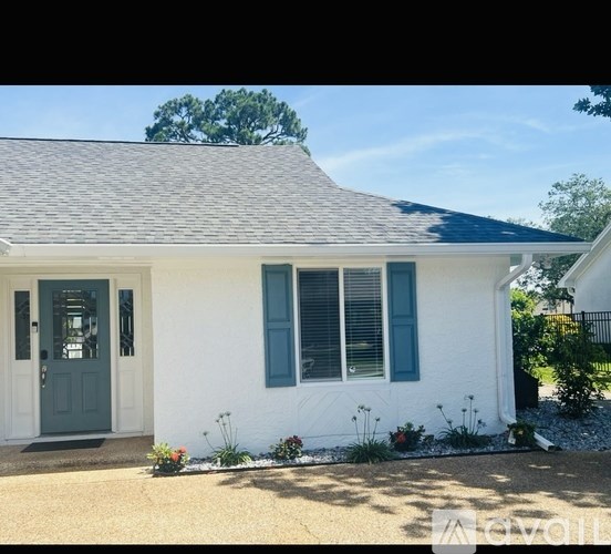 A white house with a grey roof and a grey door.