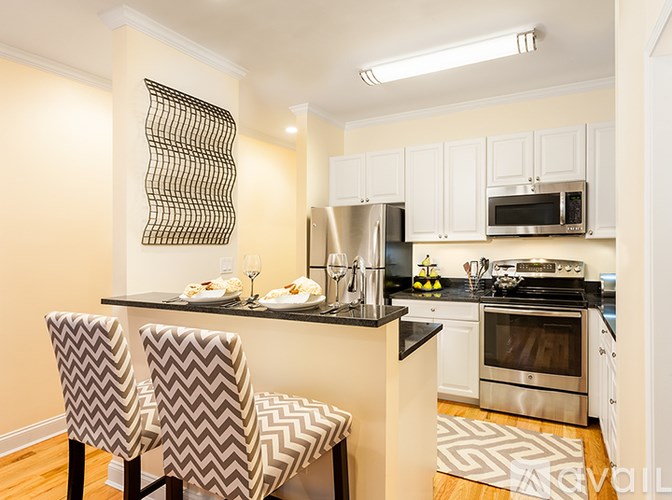 A kitchen with a black counter top and white cabinets.