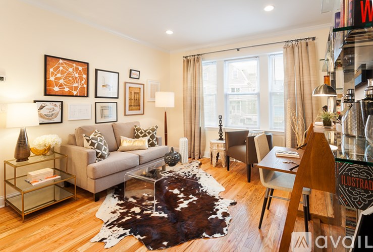A living room with a grey couch, a brown cowhide rug, and a wooden coffee table.