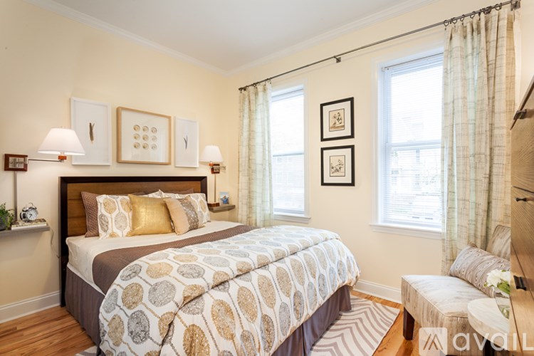 A bedroom with a large bed and a window with curtains.