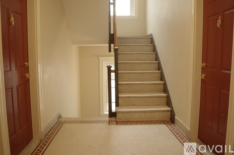 A staircase with a red carpeted landing.