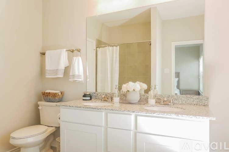 A white bathroom with a toilet, sink, and mirror.