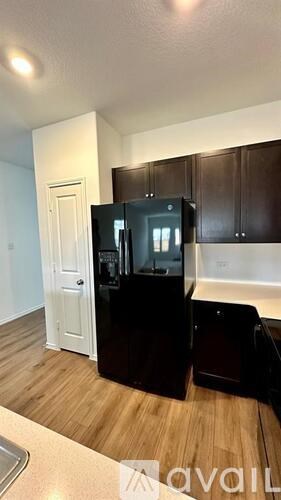 A kitchen with black cabinets and a white door.
