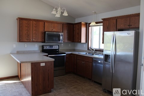 A kitchen with wooden cabinets and stainless steel appliances.