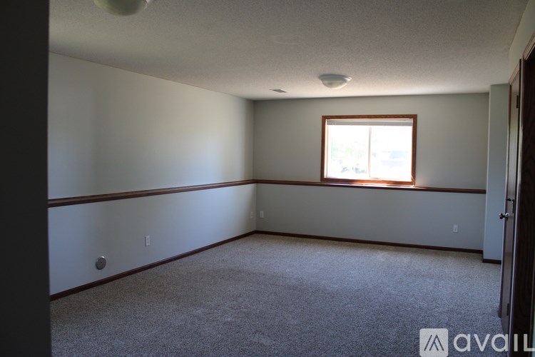 A room with a window and carpeted floor.