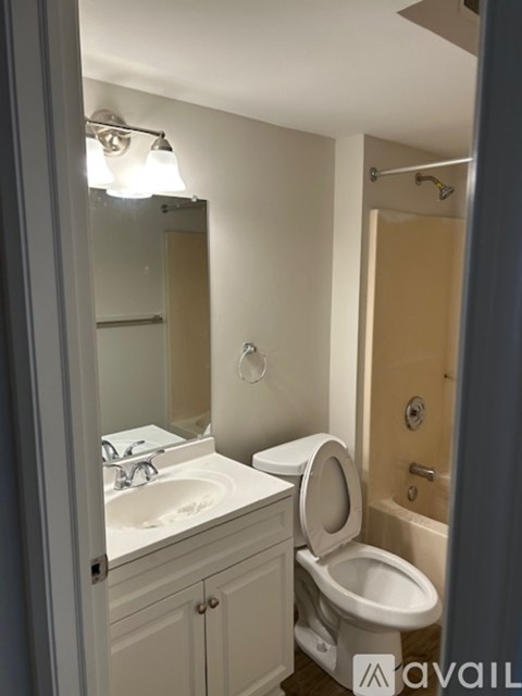 A bathroom with a toilet, sink, and mirror.