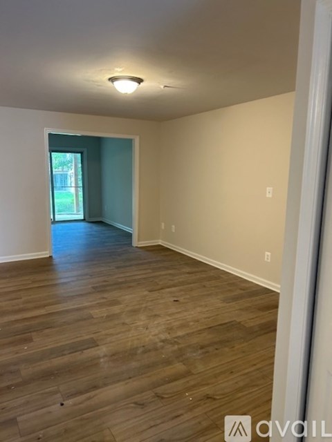 A room with wooden flooring and a window.