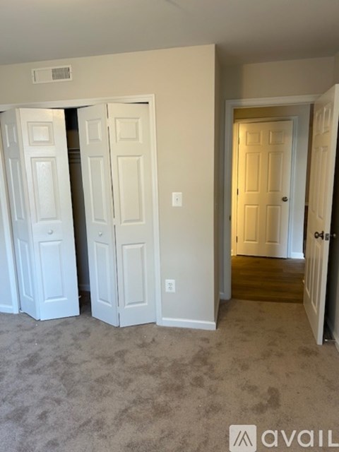 A room with three white doors and a carpeted floor.