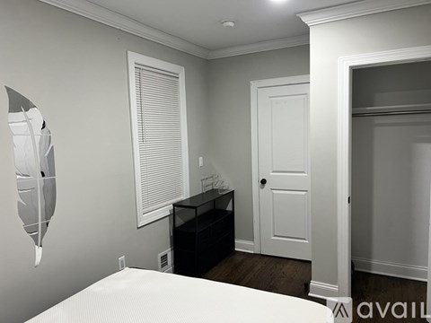 A bedroom with a bed, dresser, and mirror.