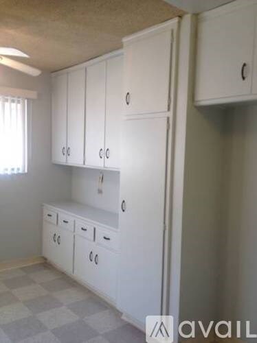A kitchen with white cabinets and drawers.