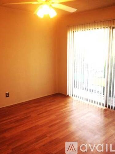 A room with wooden floors and a ceiling fan.