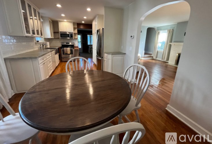 A kitchen with a table and chairs in the foreground.