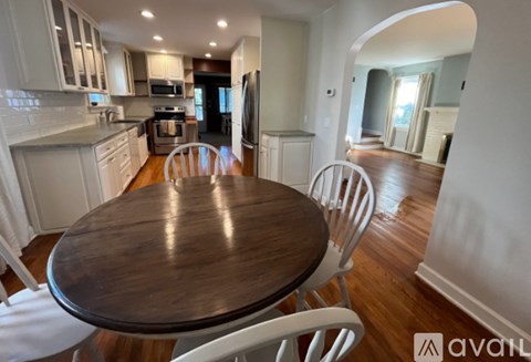 A kitchen with a table and chairs in the foreground.