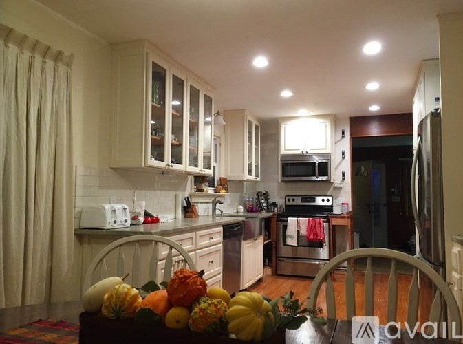 A kitchen with a table full of fruits and vegetables.