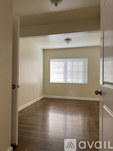 A white door is open to a bathroom with a tub and shower.