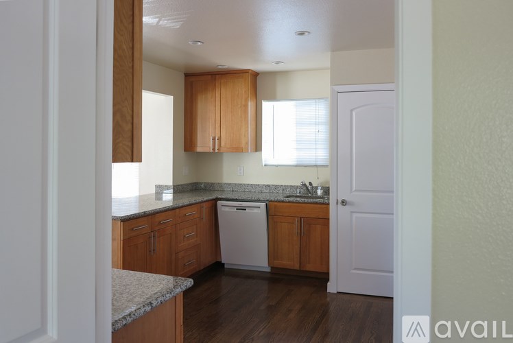 A kitchen with wooden cabinets and a white dishwasher.