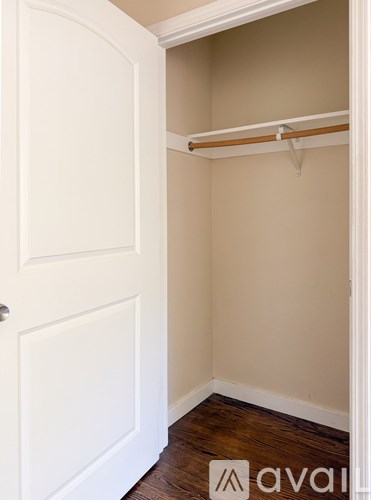 A white door is open to a small closet with a shelf.