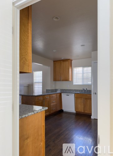 A kitchen with wooden cabinets and a granite countertop.