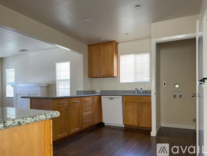 A kitchen with wooden cabinets and a granite countertop.