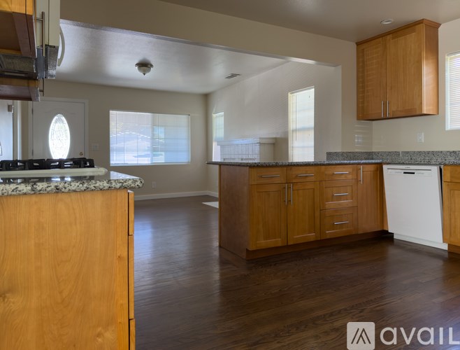 A kitchen with wooden cabinets and a granite countertop.