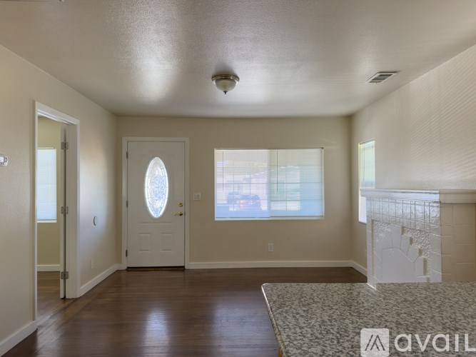 A room with a door, a window, and a ceiling fan.