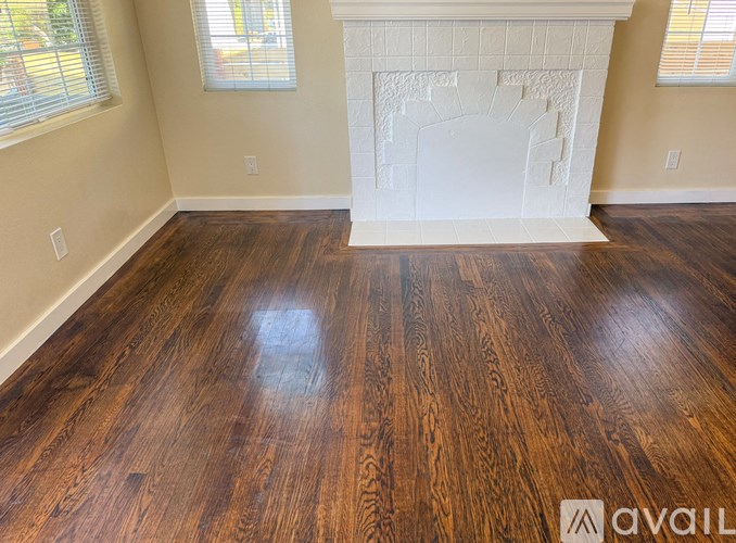 A room with a fireplace and wood flooring.