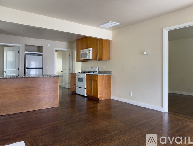 A kitchen with granite countertops and a stainless steel refrigerator.