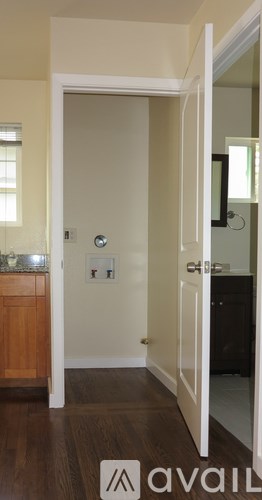 A white door with a silver handle is open.