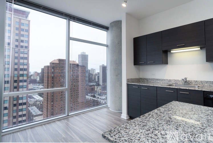 A kitchen with a marble countertop and a view of the city.