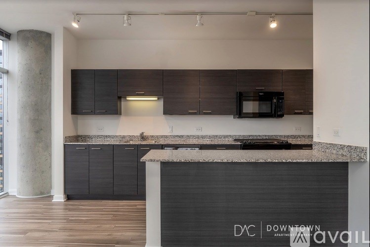 A kitchen with a counter top and a microwave.