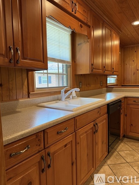 A kitchen with wooden cabinets and a white sink.