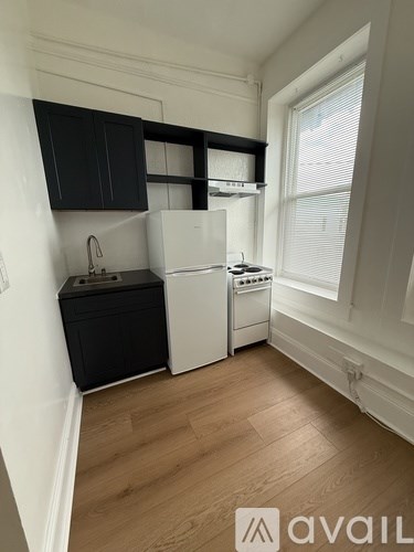 A kitchen with black cabinets and white appliances.