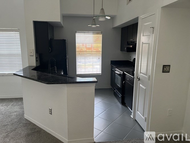 A kitchen with black appliances and white cabinets.