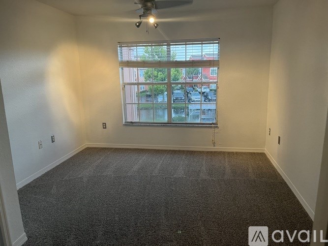 A room with a window overlooking a parking lot.