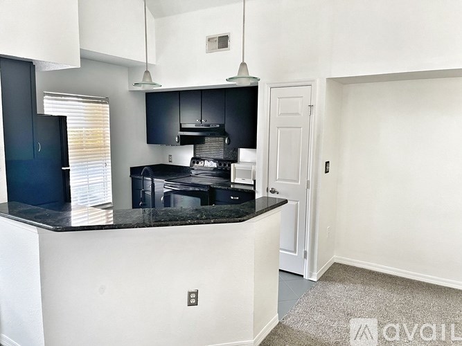 A kitchen with black countertops and white cabinets.