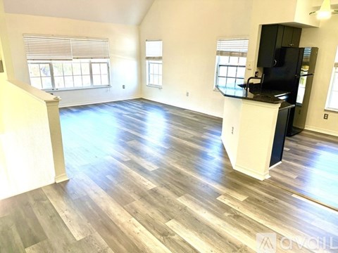 A living room with wood flooring and a television on a cabinet.
