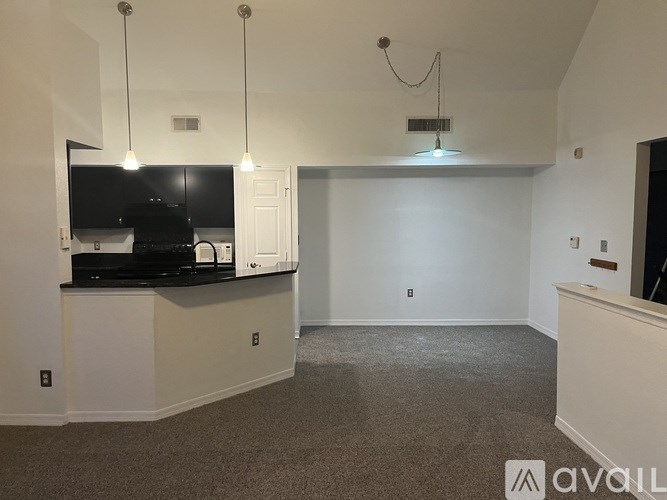 A living room with a television, a black countertop, and a white cabinet.