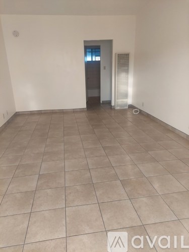 A room with a tiled floor and a door leading to another room.