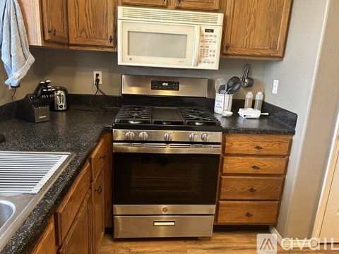 A kitchen with a stove top oven and microwave above it.