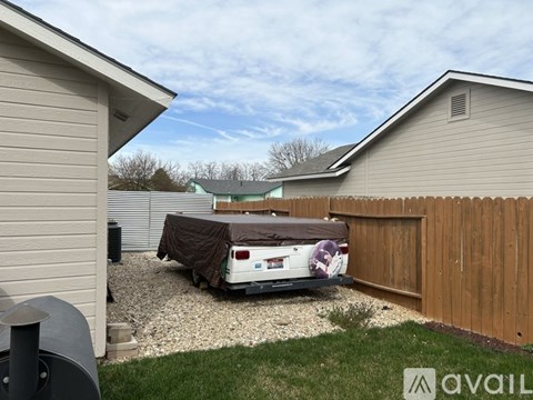 A car covered in a brown tarp is parked in a driveway.