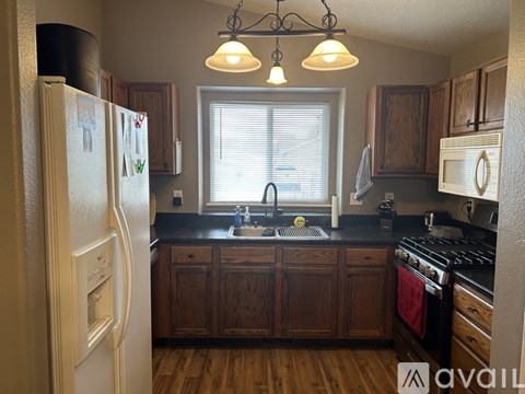 A kitchen with wooden cabinets and a white refrigerator.