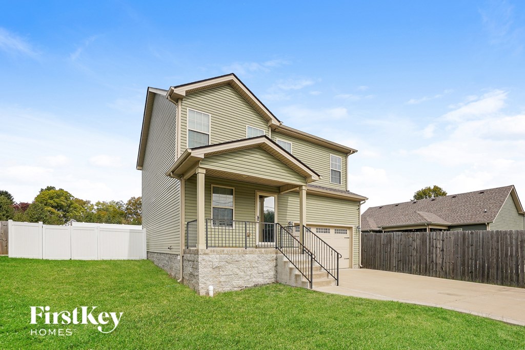 A house with a white fence and a brown roof is for sale.