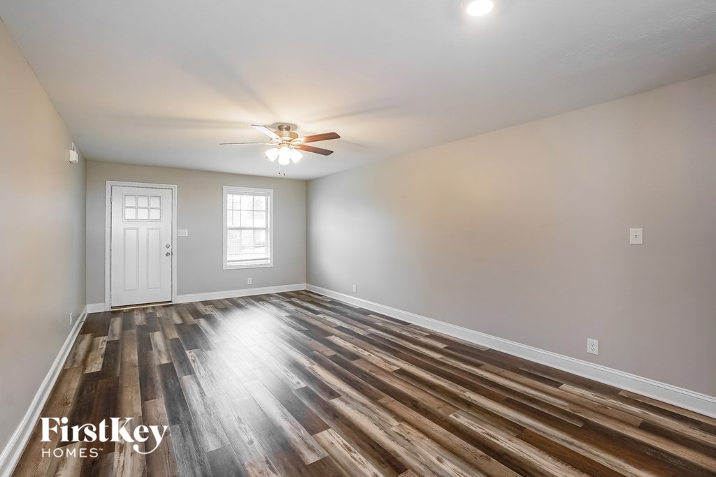 A room with wooden floors and a ceiling fan.