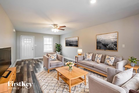 A living room with a couch, chairs, and a coffee table.
