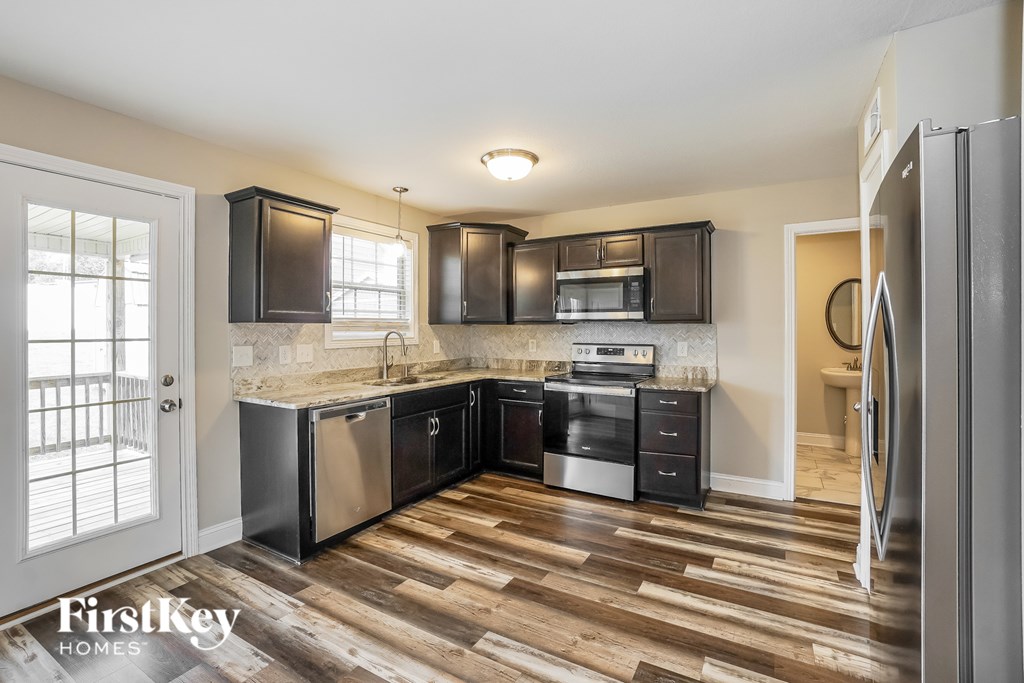 A kitchen with wooden floors and stainless steel appliances.