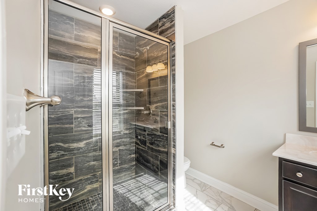 A bathroom with a walk-in shower and a white counter.
