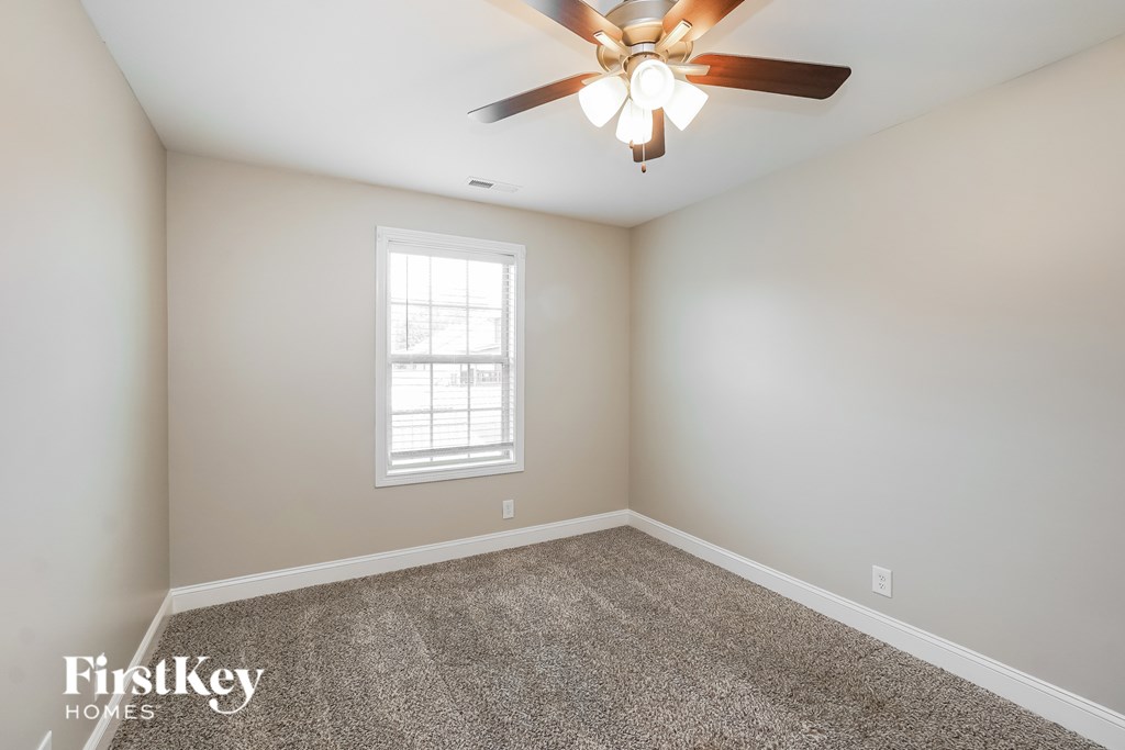 A room with a ceiling fan and a window.
