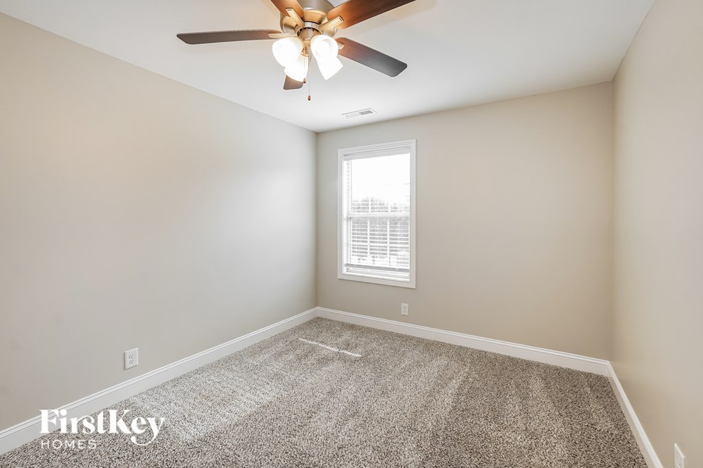 A room with a ceiling fan and a window.